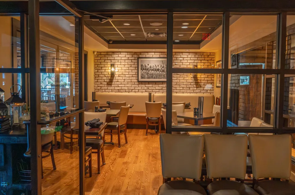 A bright dining room with wood floors seen through glass partitions
