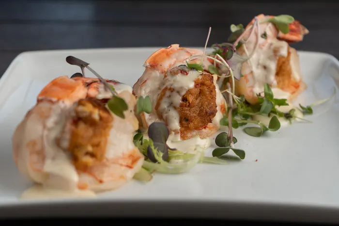 Three colossal shrimp stuffed with crab and drizzled with butter sauce