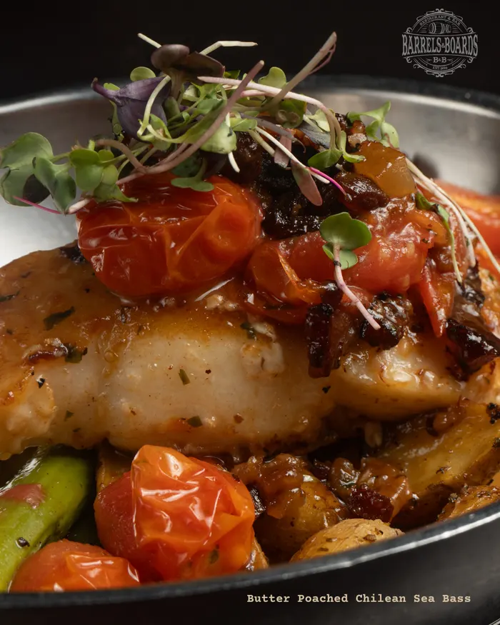 Butter poached Chilean sea bass with blistered tomatoes and asparagus