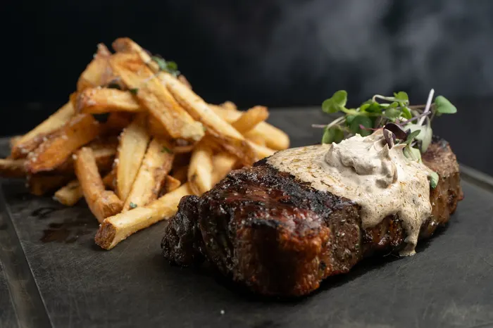 Seared steak with hand-cut fries and a creamy peppercorn sauce