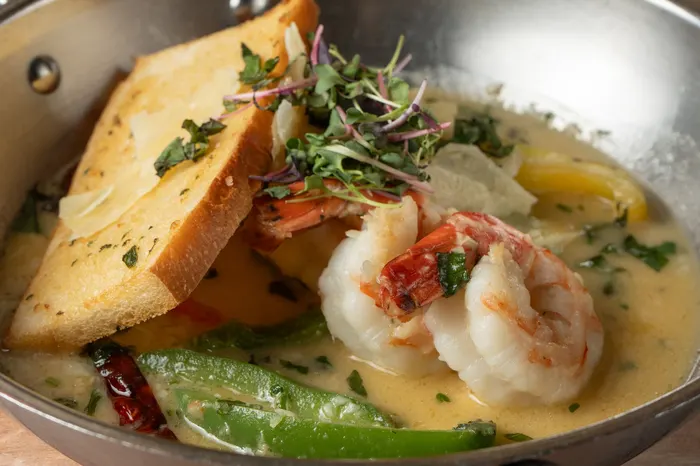 Garlic butter shrimp in a skillet with grilled baguette